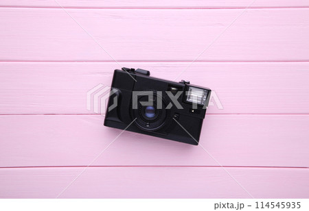 Vintage camera on pink wooden background. Old photo camera on background Vintage camera on pink wooden background. Old photo camera on background 114545935