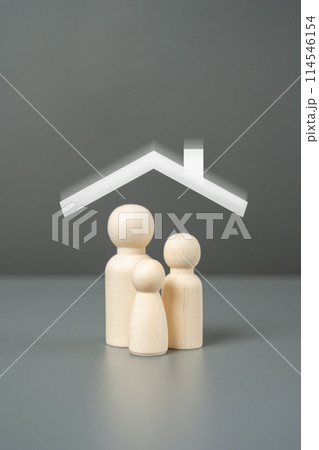 New home for a family. A family of figurines and a house roof overhead. Affordable housing concept. Buy an apartment with a mortgage. 114546154