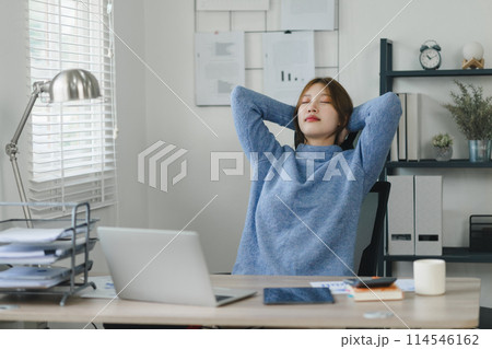 Young woman taking a relaxing stretch break in her home office during work. 114546162