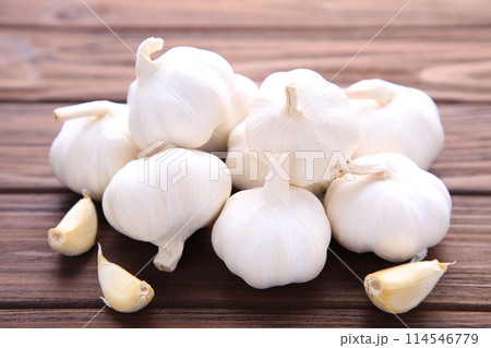 Fresh garlic on a brown wooden background Fresh garlic on a brown wooden background 114546779
