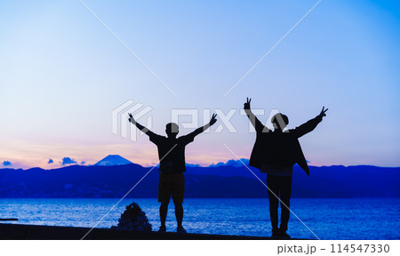 初島で夕暮れ時に海の向こうの富士山を見る人物 初島で夕暮れ時に海の向こうの富士山を見る人物 114547330