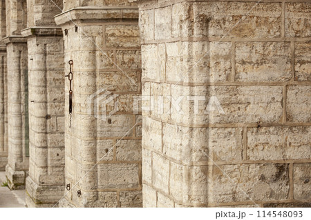 Old brick wall with arches. Weathered surface of the wall. Grunge style brick wall background. Weathered facade of a building. Horizontal. 114548093