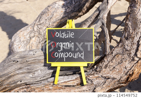 VOC volatile organic compound symbol. Concept words VOC volatile organic compound on beautiful yellow blackboard. Beautiful tree background. Business VOC volatile organic compound concept. Copy space. 114549752