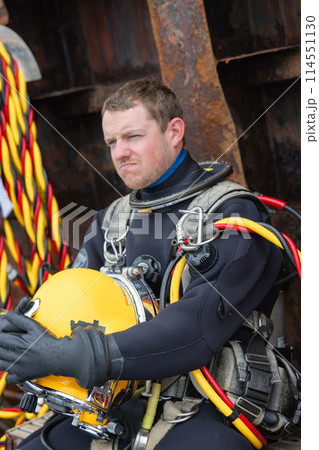 Closeup of diver holding commercial diving helmet Closeup of diver holding commercial diving helmet 114551130