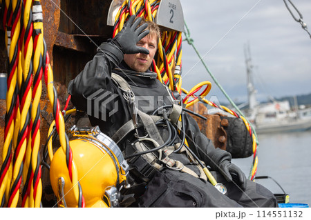 Closeup of diver holding commercial diving helmet Closeup of diver holding commercial diving helmet 114551132