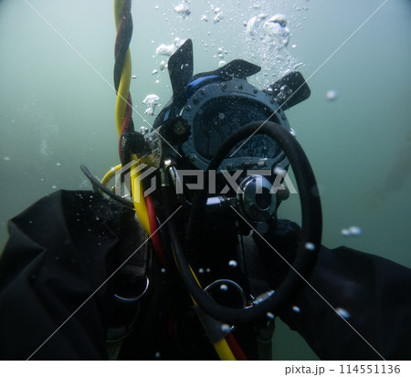Commercial diver in helmet working underwater Commercial diver in helmet working underwater 114551136