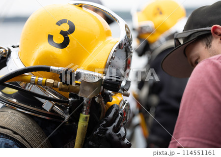 Diver assisted by tender before water entry Diver assisted by tender before water entry 114551161
