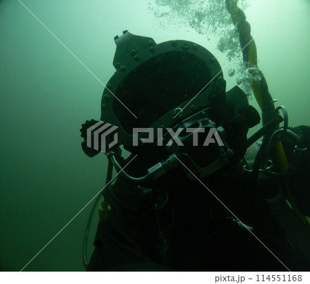 Closeup of commercial diver in helmet underwater 114551168
