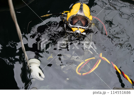 Commercial diver in Kirby Morgan helmet on water surface Commercial diver in Kirby Morgan helmet on water surface 114551686