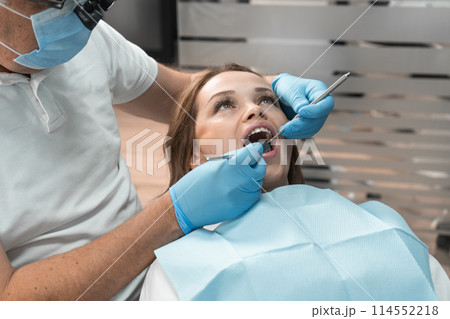 The dentist in clinic conducts professional treatment patient's teeth using advanced methods and technologies. Her attention to detail and specialized skills ensure effective and painless treatment. The dentist in clinic conducts professional treatment patient's teeth using advanced methods and technologies. Her attention to detail and specialized skills ensure effective and painless treatment. 114552218