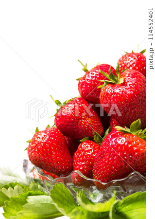 Ripe tasty strawberries in a glass vase with green leaves Ripe tasty strawberries in a glass vase with green leaves 114552401
