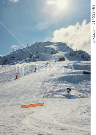 Snow-covered ski lane on mountain peak 114552465