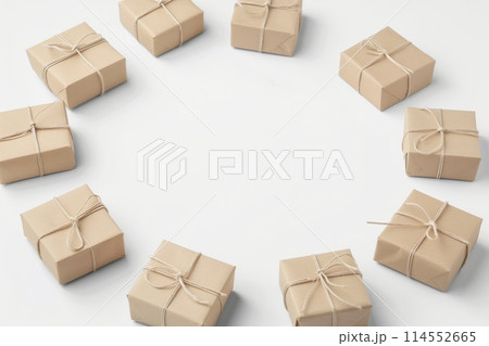 Multiple brown paper-wrapped presents tied with twine, arranged on a clean white surface 114552665