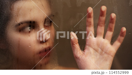 Woman touching steamy shower glass with hand Woman touching steamy shower glass with hand 114552999