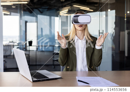 A professional young businesswoman experiences virtual reality with a VR headset in a sleek, modern office setting, surrounded by high-tech ambiance. A professional young businesswoman experiences virtual reality with a VR headset in a sleek, modern office setting, surrounded by high-tech ambiance. 114553656