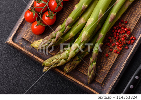 Sprigs of raw green asparagus as an ingredient for preparing a healthy breakfast 114553824