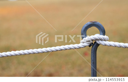 Metal stake and rope fences on a farmland, outside a city park. Metal stake and rope fences on a farmland, outside a city park. 114553915