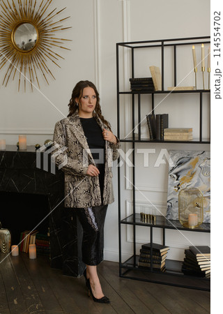 A psychologist girl in a business style poses in an interior photo studio. 114554702