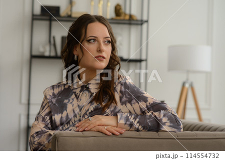 A psychologist girl in a business style poses in an interior photo studio. A psychologist girl in a business style poses in an interior photo studio. 114554732