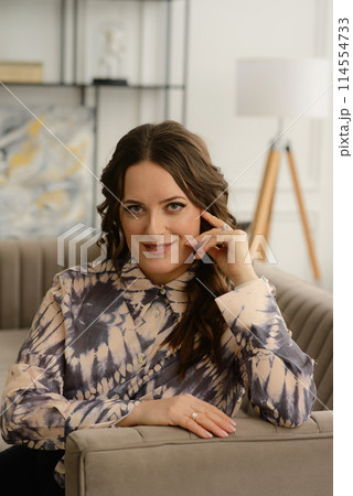 A psychologist girl in a business style poses in an interior photo studio. 114554733