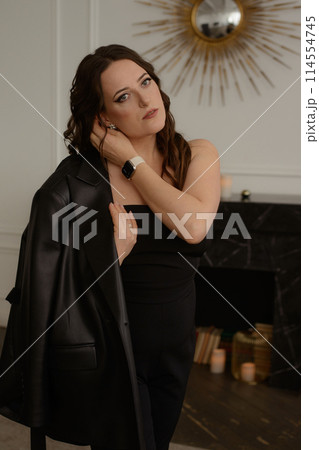 A psychologist girl in a business style poses in an interior photo studio. 114554745