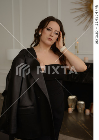 A psychologist girl in a business style poses in an interior photo studio. A psychologist girl in a business style poses in an interior photo studio. 114554746