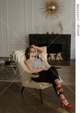 A psychologist girl in a business style poses in an interior photo studio. 114554766