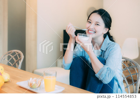 ヨーグルトを食べる若い女性 114554853