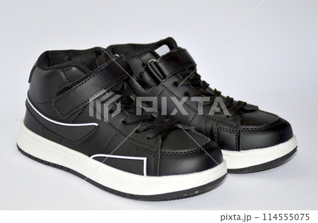 children's sneakers in black with a white stripe on the sole on white background children's sneakers in black with a white stripe on the sole on white background 114555075