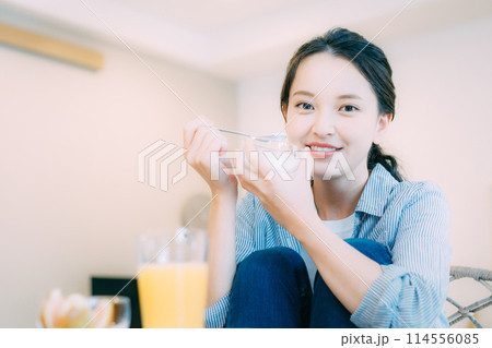 美味しそうにヨーグルトを食べる若い女性 114556085