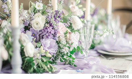 Wedding table decoration with lavender flowers, sweets, cake and candles 114556808