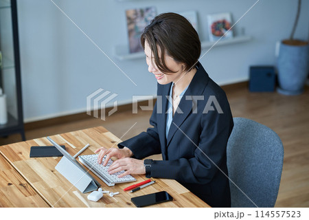 部屋で仕事をするスーツ姿の女性 部屋で仕事をするスーツ姿の女性 114557523
