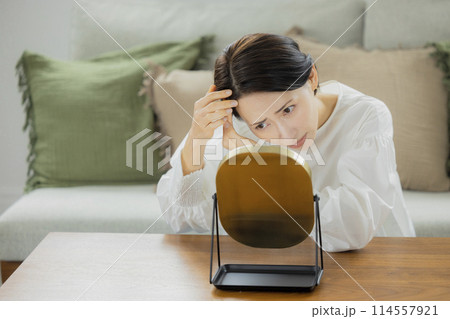 リビングで鏡を見るミドル女性 リビングで鏡を見るミドル女性 114557921