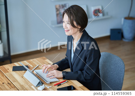 タブレットPCの前に座るスーツ姿の女性 114559365