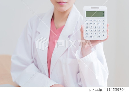 電卓で計算する女性医師 114559704