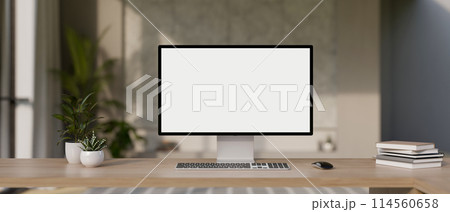 A desktop computer mockup and accessories on a wooden desk in a modern office room. A desktop computer mockup and accessories on a wooden desk in a modern office room. 114560658