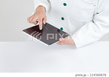 タブレットを操作する薬剤師または医師の手元。オンライン診療や遠隔医療イメージ タブレットを操作する薬剤師または医師の手元。オンライン診療や遠隔医療イメージ 114560676