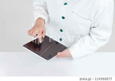 タブレットを操作する薬剤師または医師の手元。オンライン診療や遠隔医療イメージ タブレットを操作する薬剤師または医師の手元。オンライン診療や遠隔医療イメージ 114560677