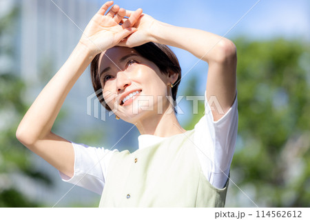 太陽の光を手で遮る女性 114562612