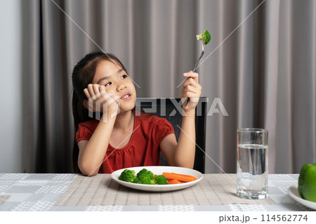 Little cute kid girl refusing to eat healthy vegetables. Children do not like to eat vegetables. 114562774