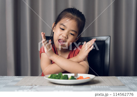 Little cute kid girl refusing to eat healthy vegetables. Children do not like to eat vegetables. 114562776