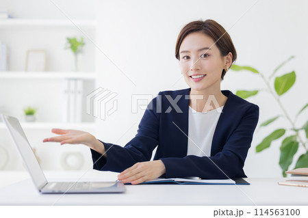 ビジネス　接客をするスーツを着た女性 114563100