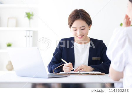 ビジネス　接客をするスーツを着た女性 114563228