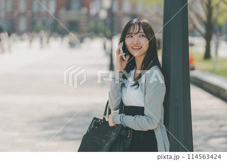 待ち合わせ場所から電話をする若い女性 待ち合わせ場所から電話をする若い女性 114563424