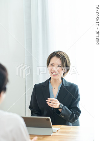 私服の女性に説明するスーツ姿の女性 114563791