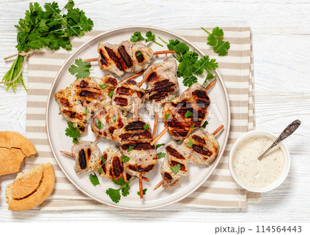 grilled mini pork skewers on a plate, top view 114564443