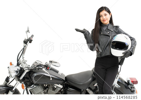 バイクの横に立って、ヘルメットを持って、指差しするバイク女子 114568285