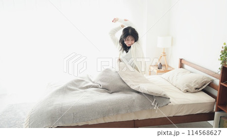 目覚めて伸びをする女性 114568627