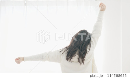 目覚めて伸びをする女性 114568633