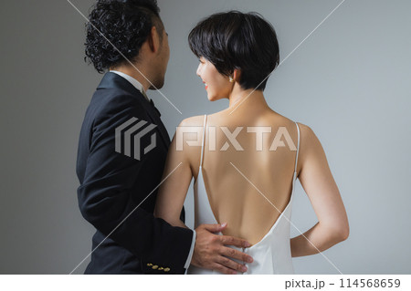 ウェディングドレスの女性とタキシードの男性  114568659